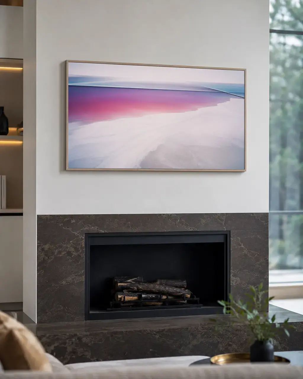 Una TV grande instalada nivelada en la pared de una sala, con los cables ocultos